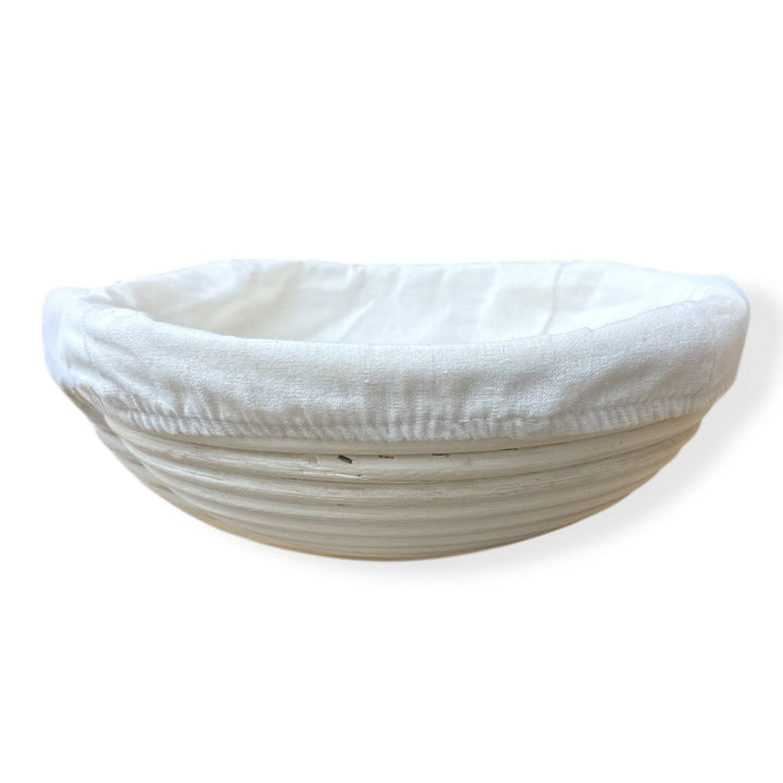 Gärkorb für Brot mit weißem Baumwolltuch abgedeckt zu sehen auf weißem Hintergrund. Bestelle hier im fitgemixt Onlineshop deinen runden Brot-Gärkorb.