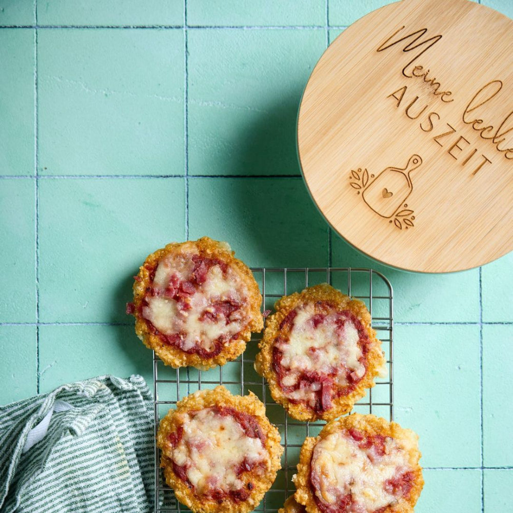 Frisch gebackene Mini-Pizzen auf Gitter neben Meal Prep Glasdose mit Deckel – für knusprige Mahlzeiten unterwegs von fitgemixt
